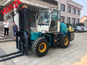 蓝色铰接式越野叉车